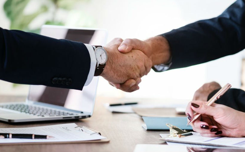 handshake across a desk partnership